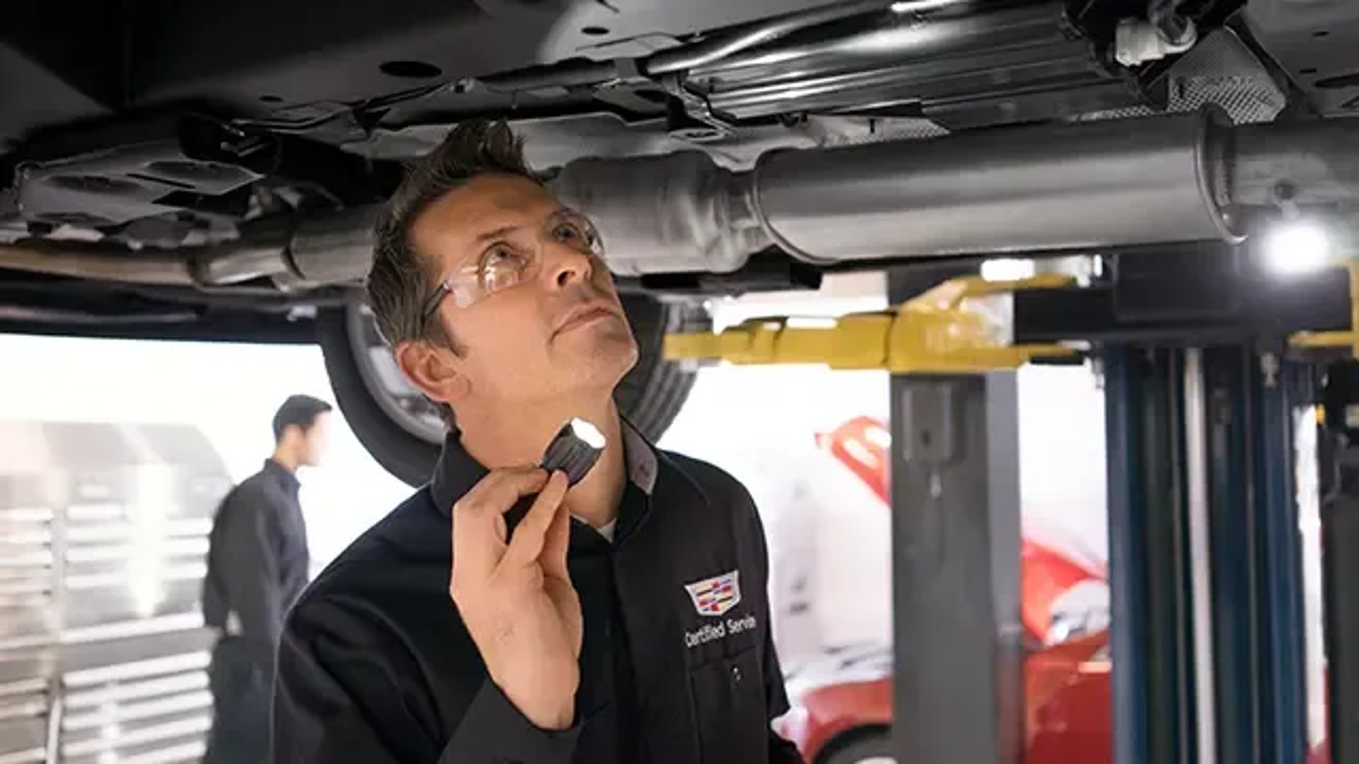 A Certified Service technician inspects the bottom of vehicle..